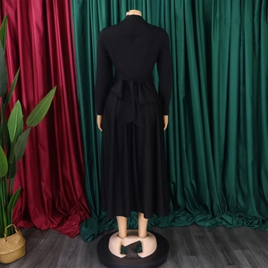 Detail of elegant black long sleeve maxi dress featuring a decorative back bow design