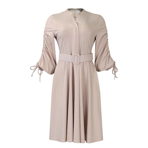 Détail d'une robe midi beige à col en V avec manches plissées et une ceinture assortie