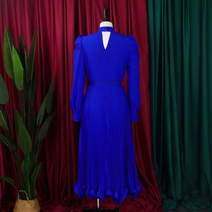 Detail view of royal blue pleated dress with puff sleeves and back cutout on mannequin