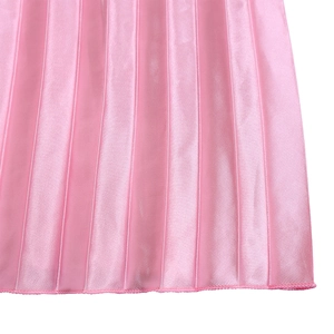 Gros plan sur le tissu satiné plissé rose vif montrant la texture soie et l'ourlet