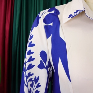 Detailed view of silky satin long sleeve dress with blue floral print and sharp lapel collar