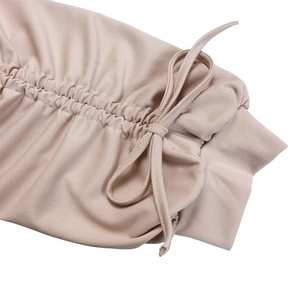 Gros plan détaillé du tissu beige plissé avec nœud de serrage sur une robe élégante