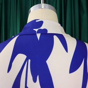 Detail shot of the V-neckline and blue abstract geometric print on the dress fabric
