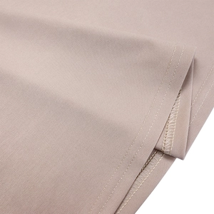 Vue macro de la couture double aiguille et du bord surjeté sur tissu en sergé