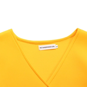 Detail of V-neckline with brand label and stitching on yellow maxi dress