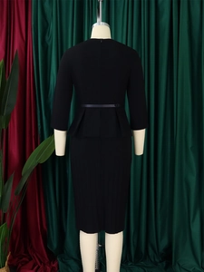 Detail of elegant black V-neck dress with peplum waist and slim belt on a mannequin