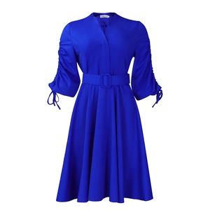 Détail de la robe bleue à col en V avec manches plissées et rubans décoratifs à nœuds