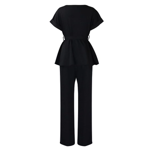 Vue arrière d'un ensemble chic haut à basque noir et pantalon taille haute femme