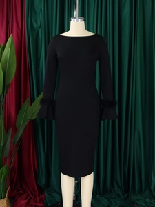 Détail de la robe moulante noire avec manches évasées et bordure en fausse fourrure chic