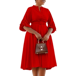 Détail d'une robe rouge à manches lanternes avec plis et ceinture assortie incluse