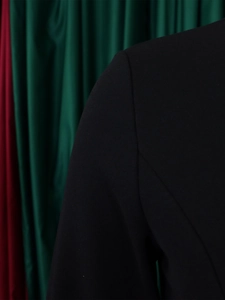 Detailed macro view of the shoulder stitching and woven fabric on this black blazer