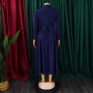 Detailed back view of a navy blue long-sleeved dress with a large waist bow and zipper