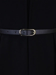 Detail of a slim black leather belt with a golden oval buckle on a high-waist pencil dress