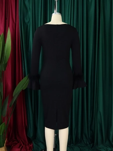Détail d'une robe midi noire avec poignets en plumes et fente arrière élégante
