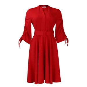 Détail d'une robe rouge à manches longues avec col en V et manches plissées à cordon