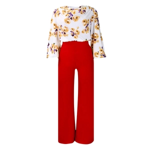Détail de chemisier en mousseline fleurie et pantalon large rouge en ensemble chic