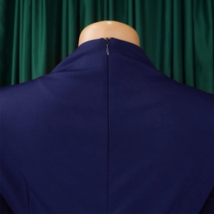 Detail view of invisible zipper closure on dark blue pleated plus size dress fabric