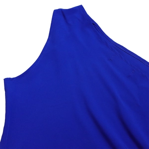 Detail of royal blue one-shoulder dress showing hollow-out neckline and fine woven texture