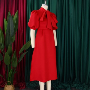 Detailed view of elegant red party dress featuring a large bow neckline and puff sleeves