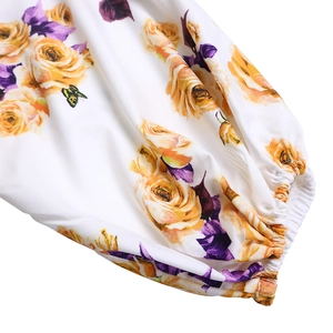 Détail du poignet élastique d'un chemisier à fleurs avec roses et motif papillon