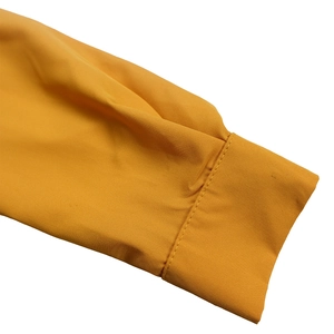 Close-up of vibrant yellow pleated fabric sleeves with precise stitching and fine texture