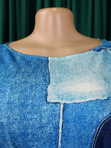 Detailed view of women's dress with round neck and vintage blue denim print texture
