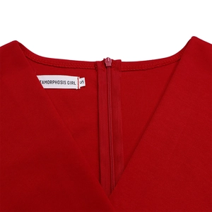 Close-up of red V-neck dress stitching and hidden zipper detail with brand label