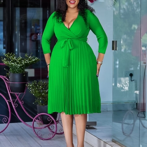 Detailed view of the V-neck wrap bodice and pleated skirt of this green fashion dress
