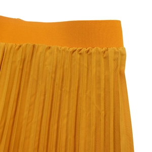 Detailed macro shot of yellow pleated skirt featuring elastic waistband and fine texture