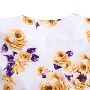 Détail de l'encolure ronde sur une blouse tissée à imprimés floraux jaunes et violets