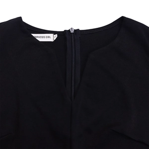Detail view of V-neckline with brand label and back zipper on black pencil dress
