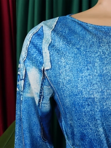 Close-up of crewneck and shoulder stitching on a blue denim print long sleeve dress