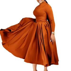 Detail of elegant pleated caramel maxi dress with long sleeves and high neckline design
