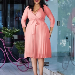 Detail of pink pleated V-neck dress featuring waist tie and elegant long sleeves