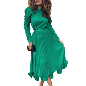 Detail of emerald green pleated maxi dress with silky satin finish and puff sleeves
