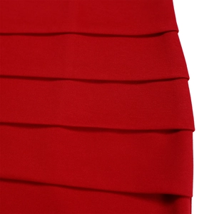Detail of red V-neck dress featuring layered ruffle tiers and stretchy knit fabric texture