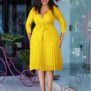 Detail of yellow V-neck long-sleeve pleated dress with a matching waist tie bow
