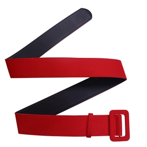 Détail d'une large ceinture en tissu rouge vif avec boucle carrée et doublure noire