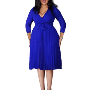 Close-up of royal blue pleated dress featuring a V-neckline and waist tie detail