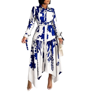 Detail of floral print maxi dress featuring irregular hem and waist-defining belt
