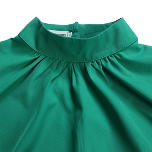 Detail of emerald green high neck top featuring elegant pleated collar and soft fabric