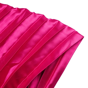 Gros plan sur le tissu satiné plissé fuchsia avec un lustre soyeux et des plis nets