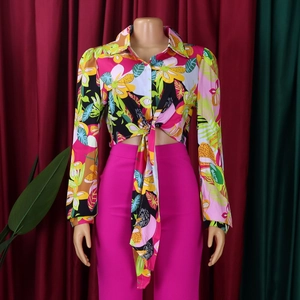 Detailed view of women's floral long sleeve shirt with tie-front and pink high waist pants