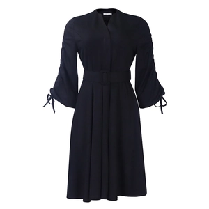 Détail de robe noire à col en V avec manches longues froncées et poignets à nœuds