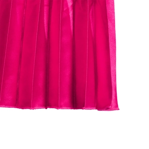 Détail du tissu satiné plissé rose rouge avec coutures fines et plis verticaux réguliers
