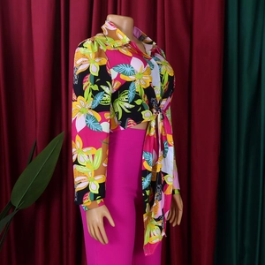 Detail of floral print long sleeve shirt with lapel collar and waist tie detail