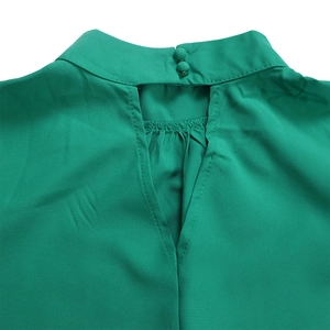 Detail of emerald green blouse featuring high neck collar with back fabric buttons and teardrop cutout