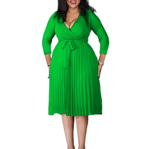 Detail of elegant V-neck pleated dress featuring a high waist tie in vibrant green fabric