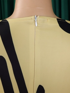 Detail view of smooth invisible back zipper on yellow abstract print floral dress