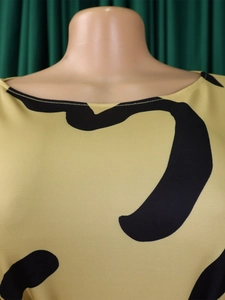 Detail of boat neck printed dress with yellow knit texture and black heart pattern